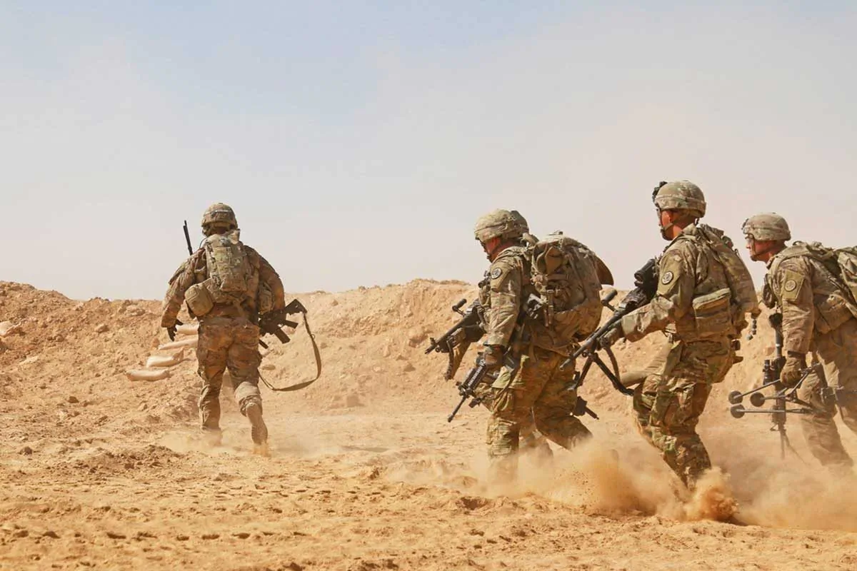 Soldiers assigned to the 3rd Cavalry Regiment rush to a berm to establish a hasty fighting position during a live-fire training exercise near Al Asad Air Base, Iraq, on Sept. 26, 2018. (U.S. Army National Guard photo by 1st Lt. Leland White)