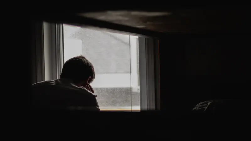 File photo of a man looking out of a window. (Unsplash/Andrik Langfield)