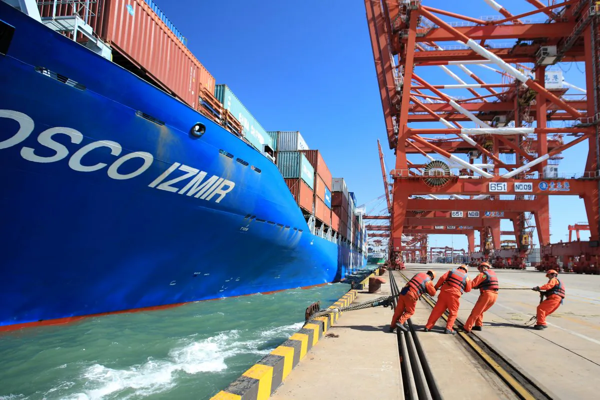 Workers help to dock a China Ocean Shipping Company (COSCO) container ship at a port in Qingdao, Shandong Province, China on Oct. 19, 2018. (Reuters) 