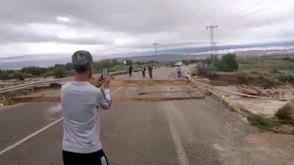 A man records video on a crumbling bridge