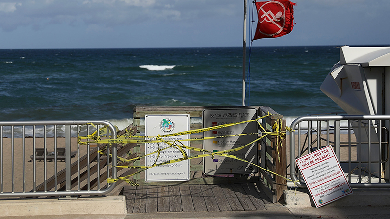 Caution tape closes off an entrance to the beach