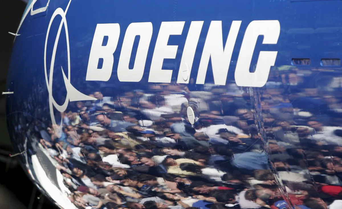 Invited guests for the world premiere of the Boeing 787 Dreamliner are reflected in the fuselage of the aircraft at the 787 assembly plant in Everett, Washington, on July 8, 2007. (Robert Sorbo/Reuters)