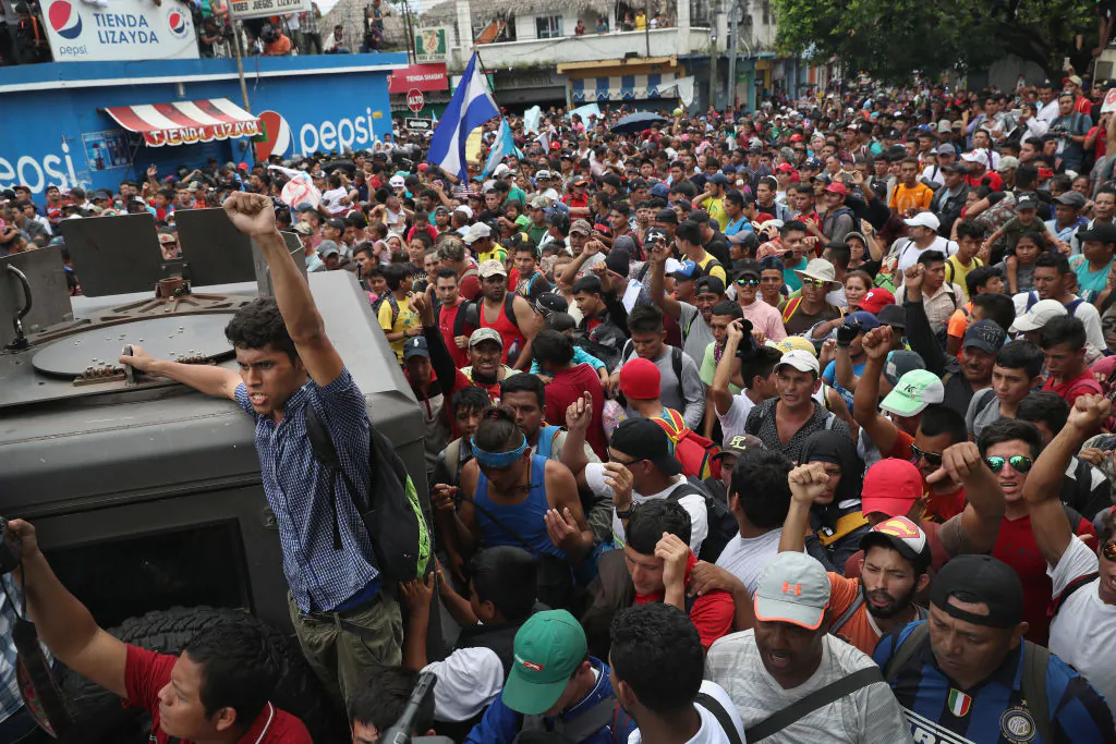 Members of the migrant caravan push forward at a gate separating Guatemala from Mexico in Ciudad Tecun Uman, Guatemala, on Oct. 19, 2018. (John Moore/Getty Images)