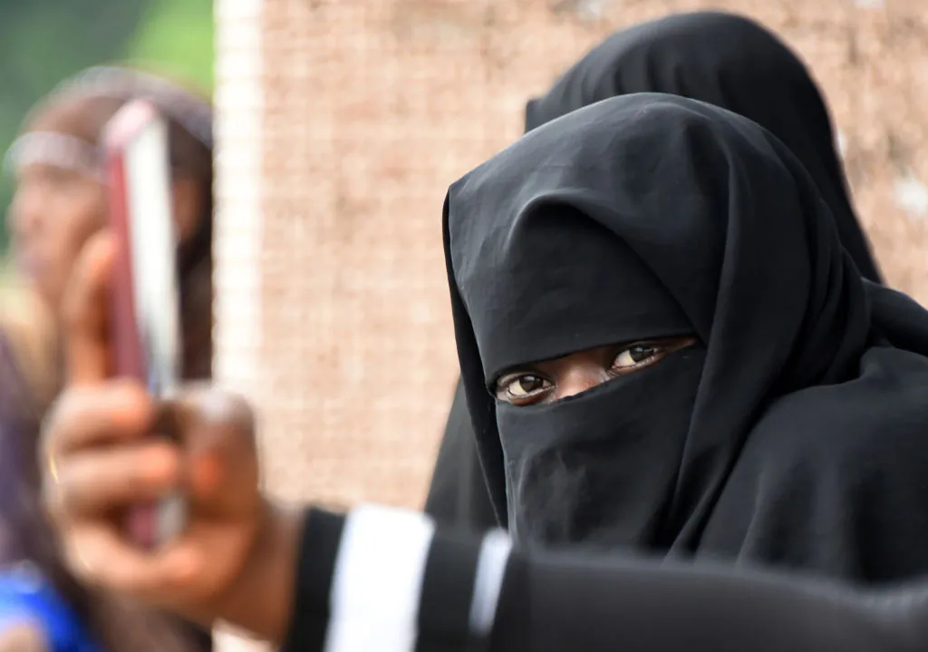 A Muslim woman wearing the niqab attends prayers at the site of a bus terminal in Adjame, a quarter of Abidjan, on Jun. 14, 2018, (Sia Kambou/AFP/Getty Images)