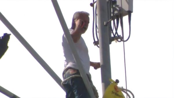 Pablo Torres talks to police from atop a cell tower