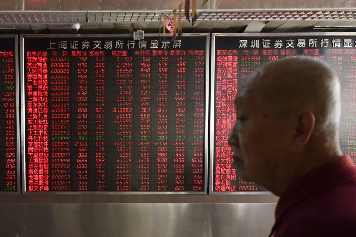 An investor stands in front of a screen showing stock prices at a securities company in Beijing on Oct. 19. (Greg Baker/AFP/Getty Images)
