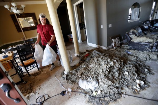 Castor Gay, who plays center for the Mosley High football team, cleans debris