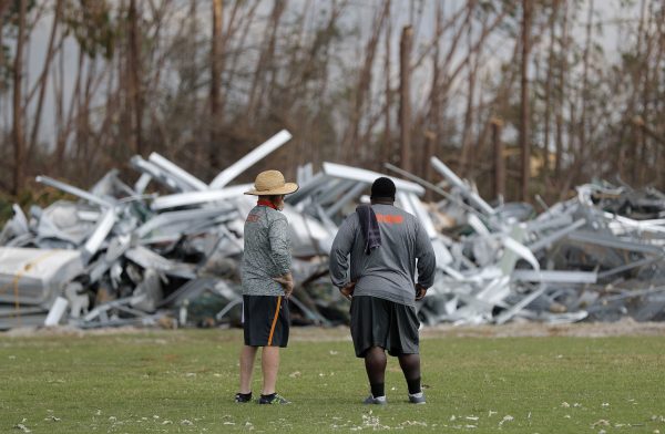 Mosley High defensive coordinator Danny Nagy, left, and defensive line coach William Mosley, survey damage
