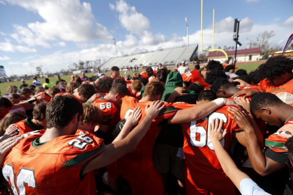 Coaches and players from Mosley High pray together