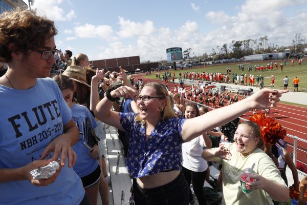 People attend and cheer the football game