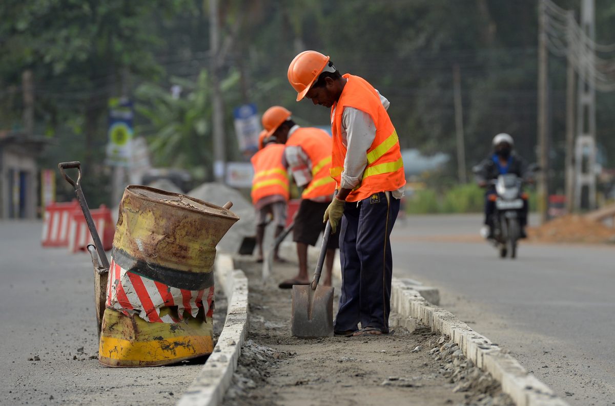 Sri Lankan construction laborers work along a road in Colombo.