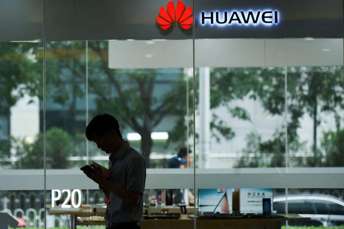 A man uses his mobile phone outside a Huawei store in Beijing on August 7, 2018. (WANG ZHAO/AFP/Getty Images)