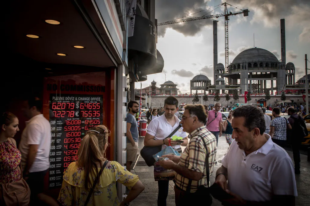 People wait to change money at a currency exchange office in front of the underconstruction, Taksim Square Mosque on Aug. 29, 2018 in Istanbul, Turkey. (Chris McGrath/Getty Images)