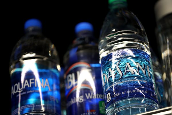 Bottles of water are displayed on a shelf at a convenience store