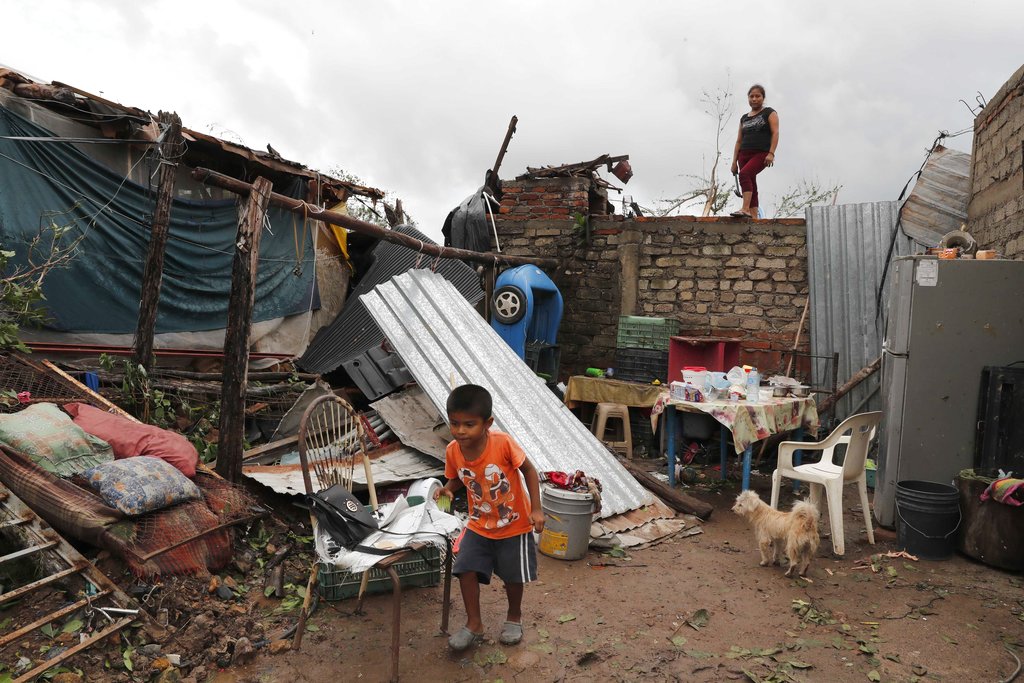 Boy walks near damaged home