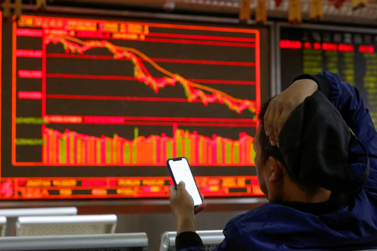 An investor sits in front of displays showing stock information at a brokerage office in Beijing on Oct. 11, 2018. (Thomas Peter/Reuters)