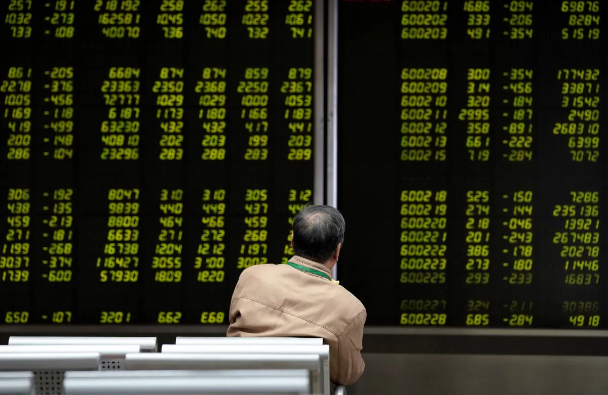 An investor watches a board showing stock information at a brokerage office in Beijing on Oct. 8, 2018. (Jason Lee/Reuters)