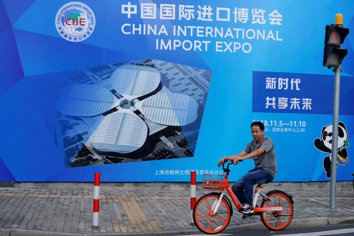 A man rides a bicycle near a billboard promoting the upcoming China International Import Expo in Shanghai, China  on Sept. 27, 2018. (Aly Song/Reuters)
