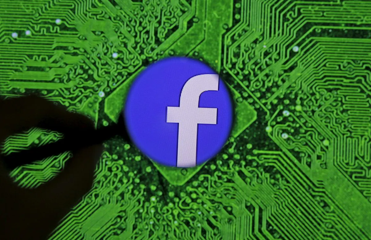 Facebook's logo is seen through a magnifier in front of a displayed PC motherboard, in this illustration taken April 11, 2016. (Dado Ruvic/Illustration/Reuters)