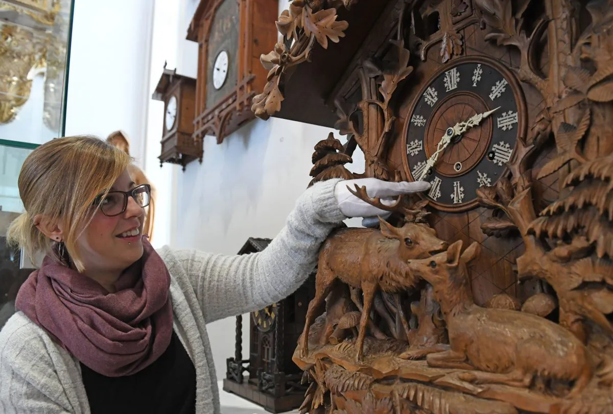 An employee moves the hands of a historic clock at the German Clock Museum in Furtwangen, Germany, on March 19, 2018. (Patrick Seeger/AFP/Getty Images)