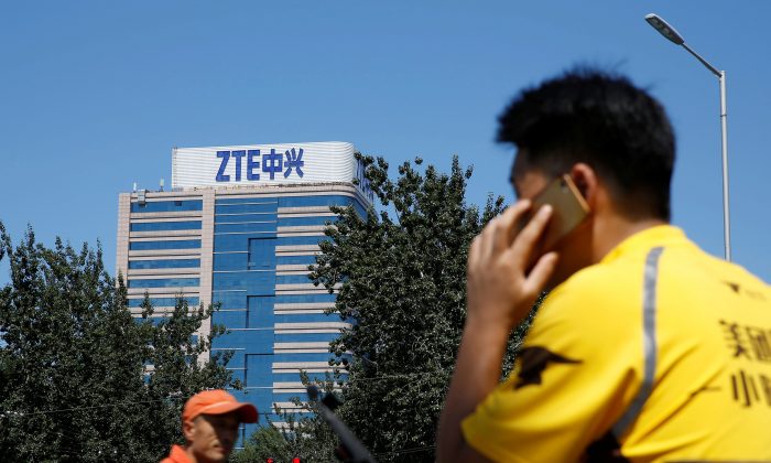 A delivery man uses a phone near a building of China's ZTE Corp in Beijing, China, August 29, 2018.  REUTERS/Thomas Peter