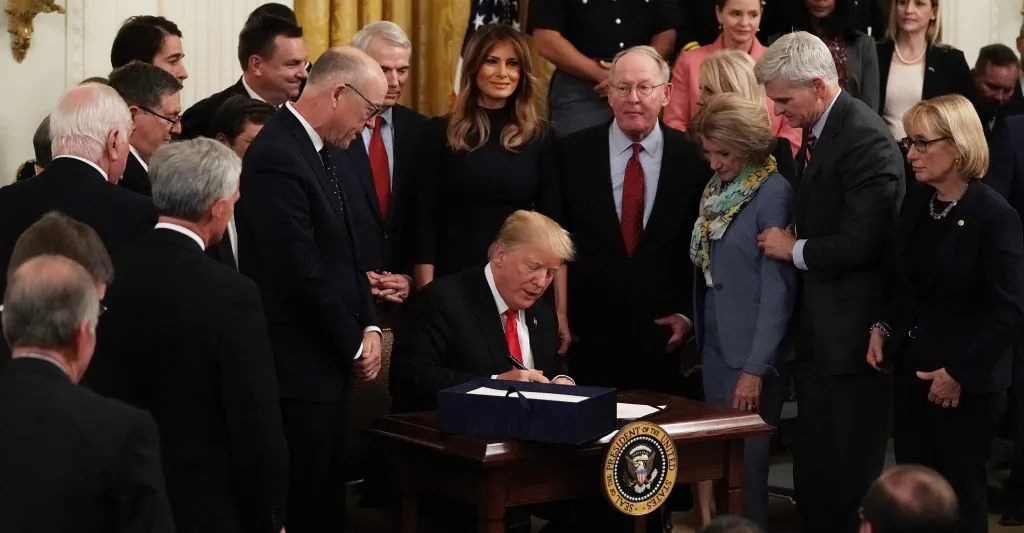 Flanked by lawmakers and first lady Melania Trump, President Donald Trump participates in a bill signing to dedicate more resources to fight the opioid crisis during an East Room event at the White House Oct.24, 2018. (Alex Wong/Getty Images)