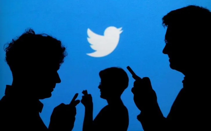 People holding mobile phones are silhouetted against a backdrop projected with the Twitter logo in this illustration picture taken in  Warsaw on Sept. 27, 2013.   (Kacper Pempel/Illustration/File Photo/Reuters)