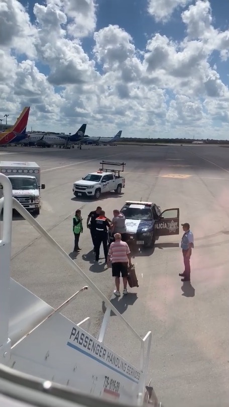 police and airport officials talk to the man