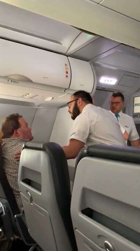 crewmembers try to calm down man