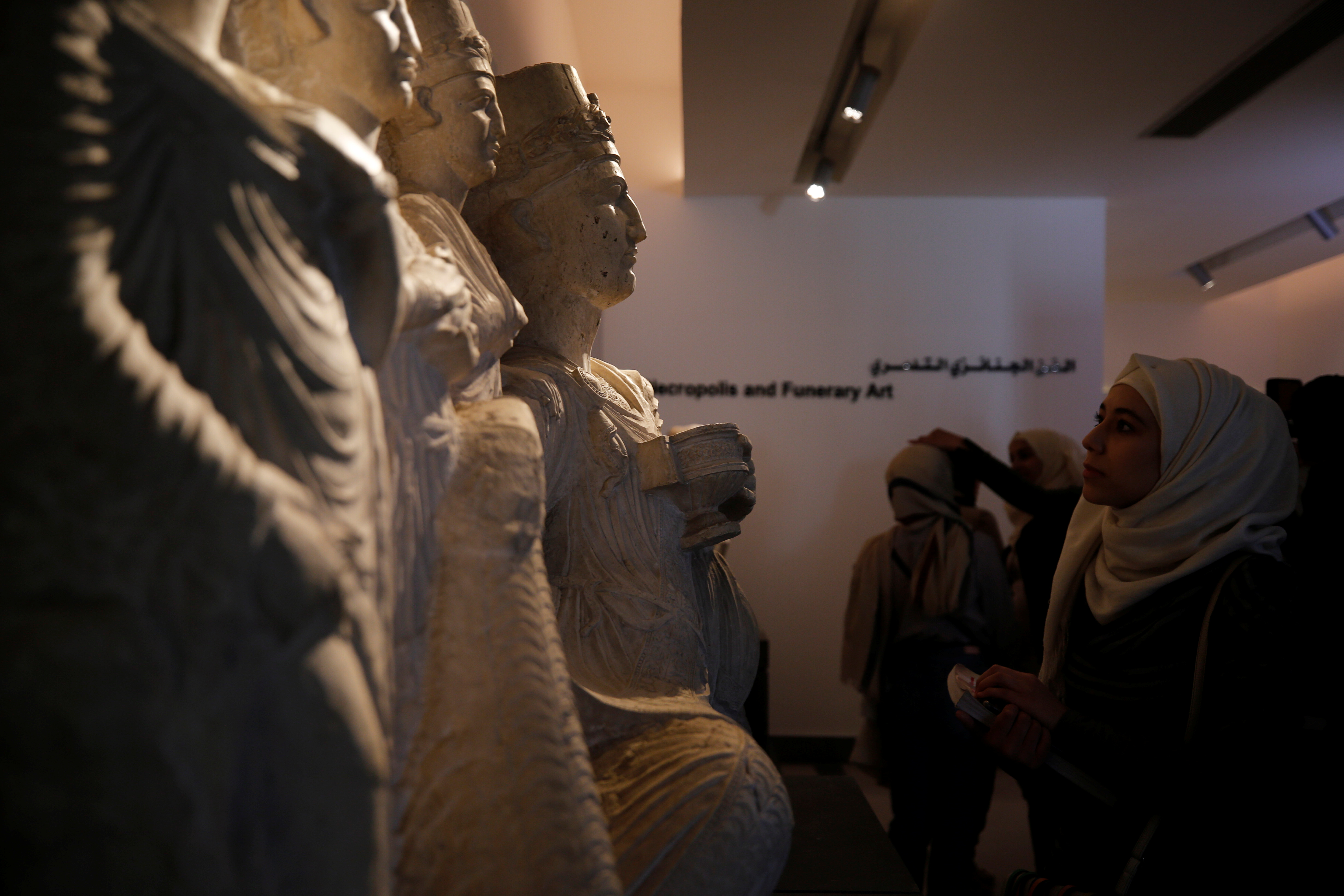 Visitors look sculptures displayed