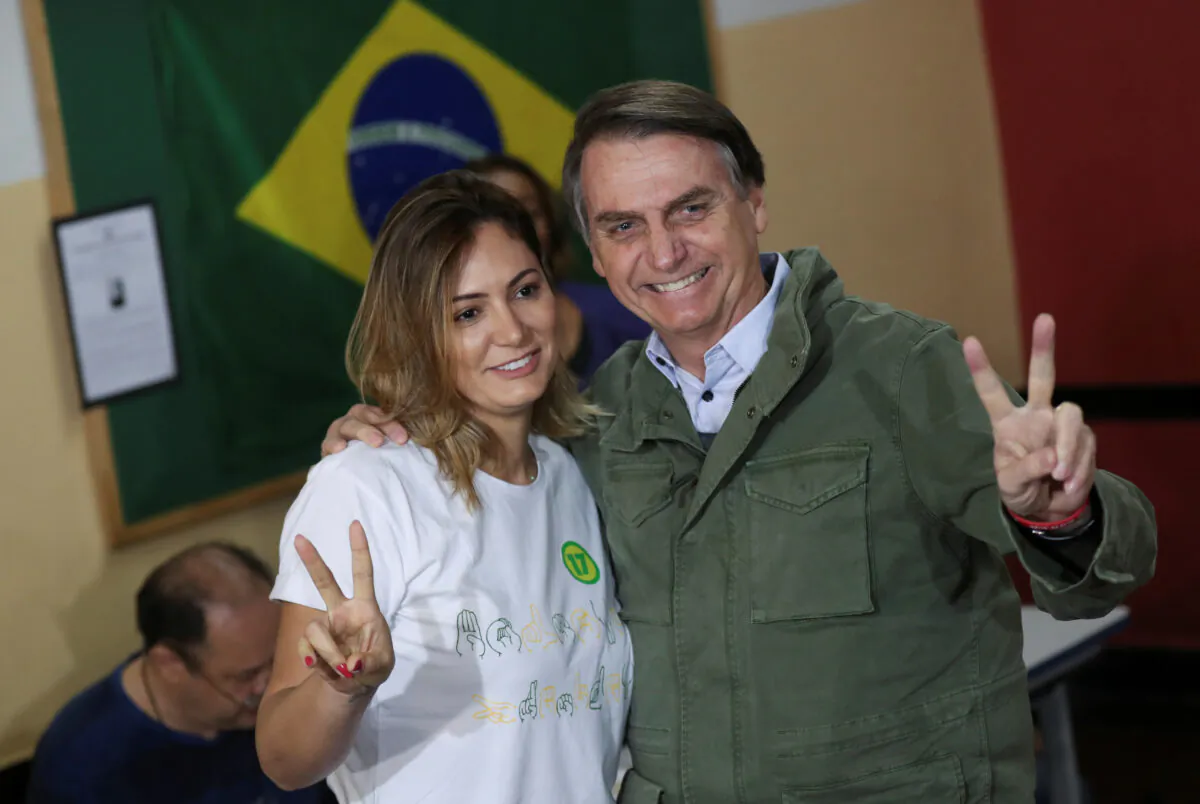 Jair Bolsonaro, newly elected president of Brazil, poses with his wife Michelle as they arrive to cast their votes at a polling center in Rio de Janeiro, Brazil Oct. 28, 2018. (Reuters/Ricardo Moraes/Pool)