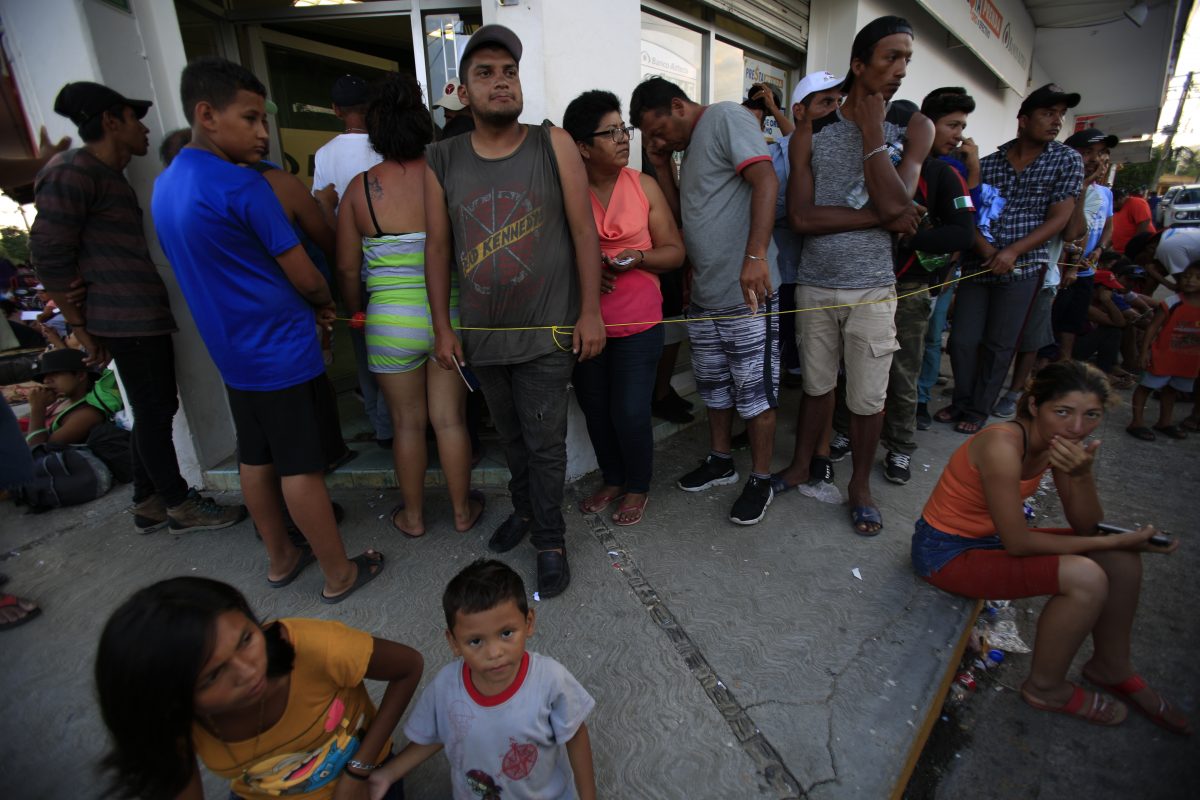 Migrants wait slow moving line