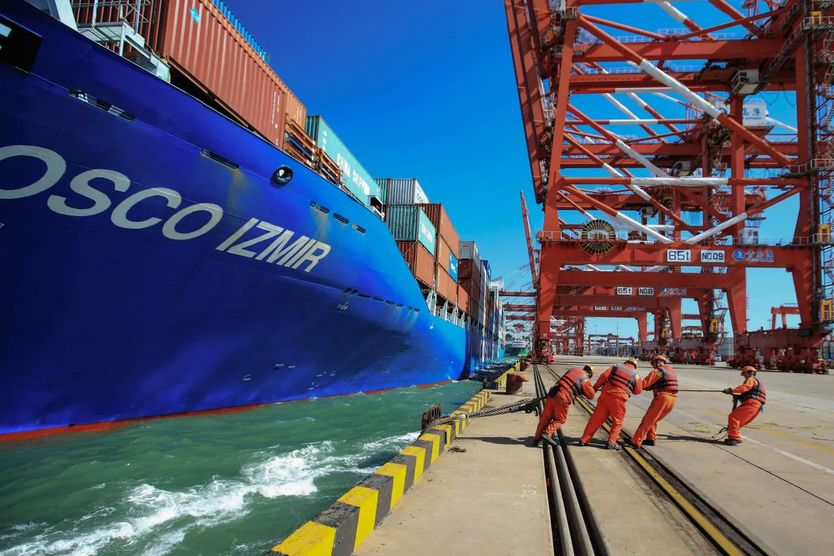 Workers pull a line from a cargo ship as it prepares to berth at a port in Qingdao in China's eastern Shandong province on October 19, 2018. China's economy grew at its slowest pace in nine years in the third quarter, as a campaign to tackle mounting debt and trade frictions with the US had an effect. (STR/AFP/Getty Images)