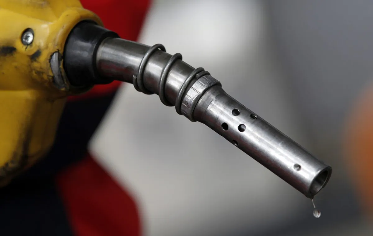 An employee holds a gas pump to refill a car at a petrol station in central Seoul on April 6, 2011. (Lee Jae-Won/Reuters)