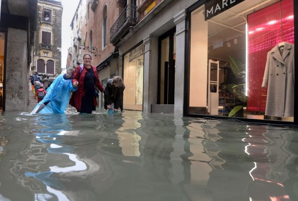People walk in a flooded street of Venice