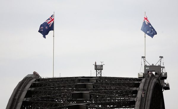 The Australian flag (R) and the New Zealand flag fly on the Sydney Harbour Bridge