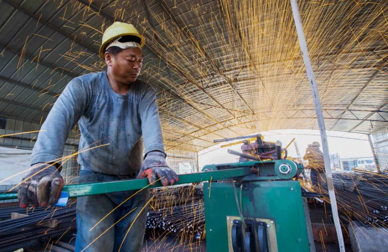A laborer cuts steel bars at a railway bridge construction site in Lianyungang, Jiangsu Province, China on Sept. 12, 2015. (China Daily/Reuters)