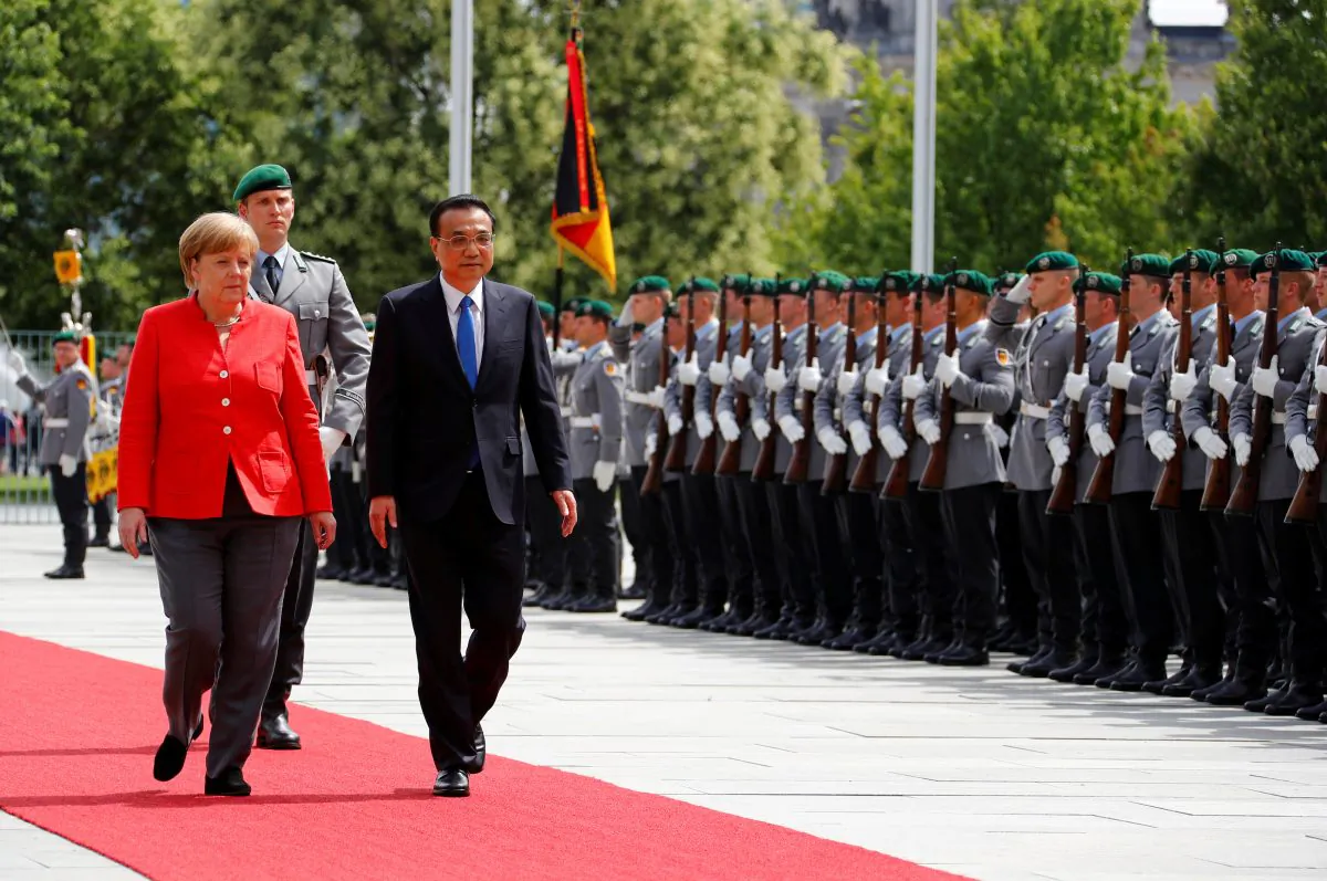FILE PHOTO: German Chancellor Angela Merkel and Chinese Prime Minister Li Keqiang review the guard of honour at the chancellery in Berlin, Germany, July 9, 2018. REUTERS/Fabrizio Bensch/File Photo