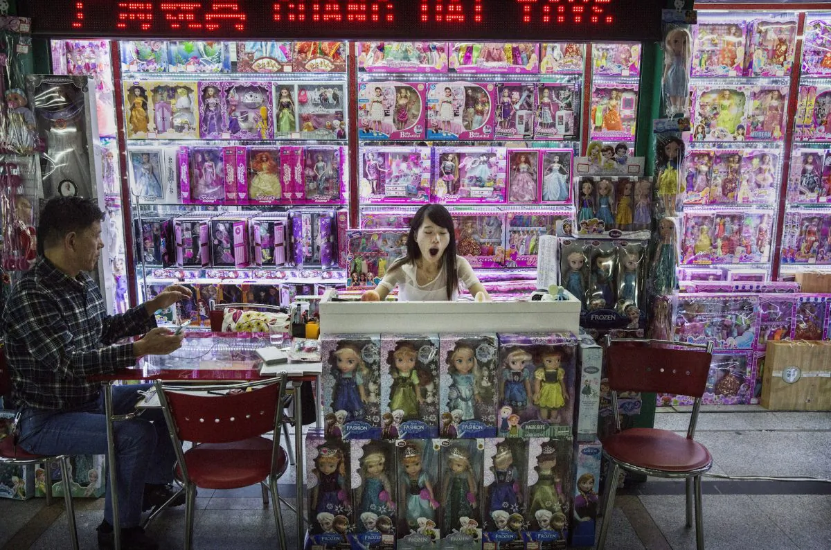 A Chinese trader yawns as she waits on customers at her stall selling wholesale dolls at the Yiwu International Trade City in Yiwu County, Zhejiang Province, on Sept. 24, 2015. (Kevin Frayer/Getty Images) 