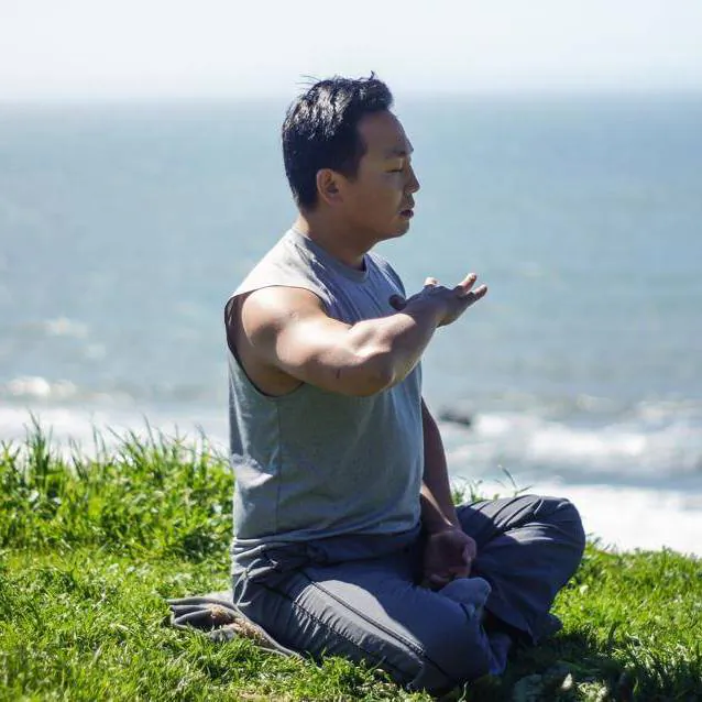 Rico Peng meditating beside San Francisco Bay. (courtesy Rico Peng)