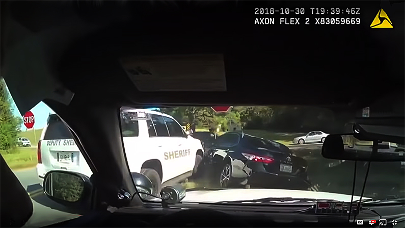 A police vehicle pins Rose Becker in her car
