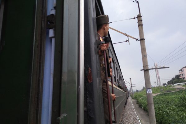 North Korean soldier looks out from train during a train journey