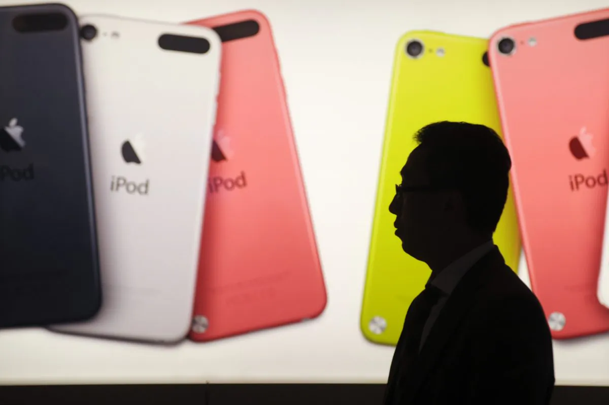A man walks past an illuminated display outside an Apple store in Hong Kong on Nov. 20, 2012. (ANTHONY WALLACE/AFP/Getty Images)