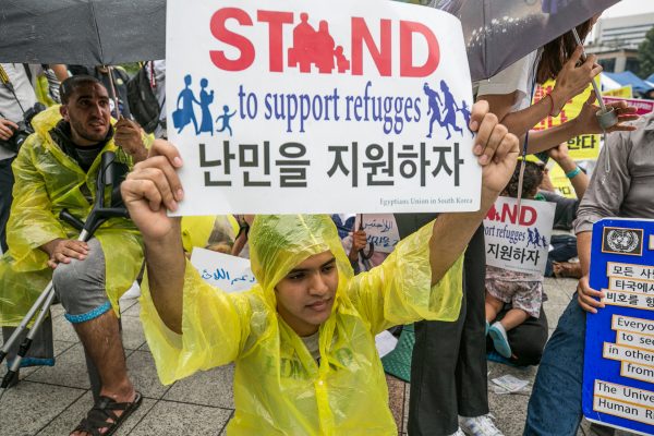 Activists hold signs in support of Yemeni asylum seekers in South Korea.