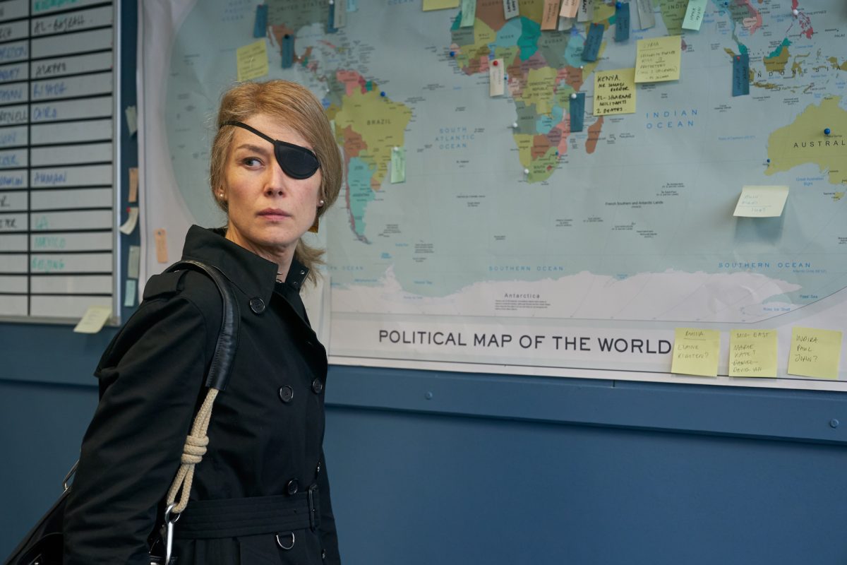 Rosamund Pike standing in front of map