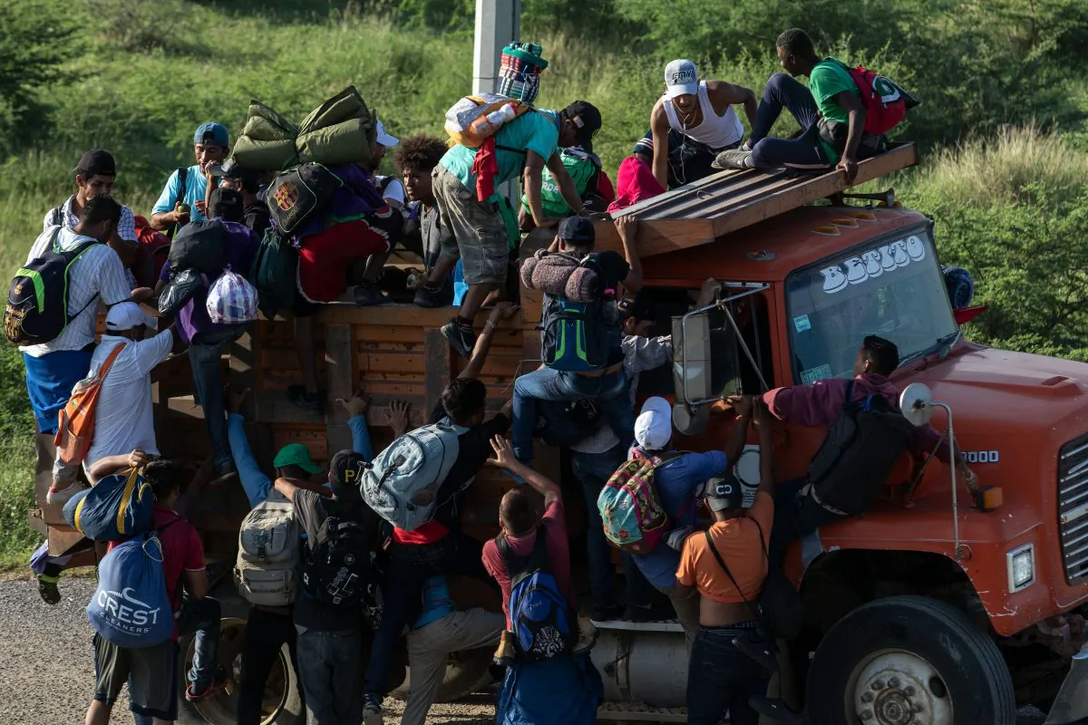 Migrants in a caravan heading to the United States climb on a truck on the road from La Ventosa to Matias Romero, Oaxaca State, Mexico, on Nov. 1, 2018. (Guillermo Arias/AFP/Getty Images)