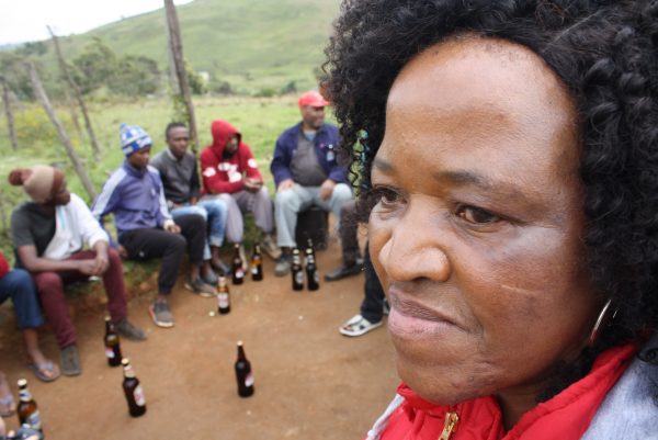 Veteran HIV counselor Gethwana Mahlase speaks to men outside a tavern in Vulindlela.