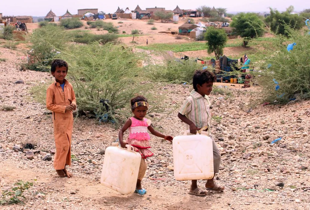 Displaced Yemeni children from Hodeida carry water containers as they walk to a nearby well to fill them in the northern district of Hajjah province, on October 22, 2018. (ESSA AHMED/AFP/Getty Images)