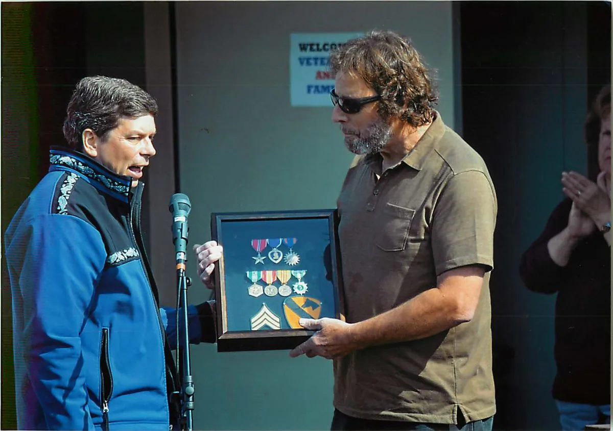 Sen. Mark Begich (D-Ala.) (L) delivers several medals to Randy Clifford in 2014 that were awarded to him but were lost when he was flown back to San Francisco from Vietnam after being shot. (Photo Courtesy of Randy Clifford)