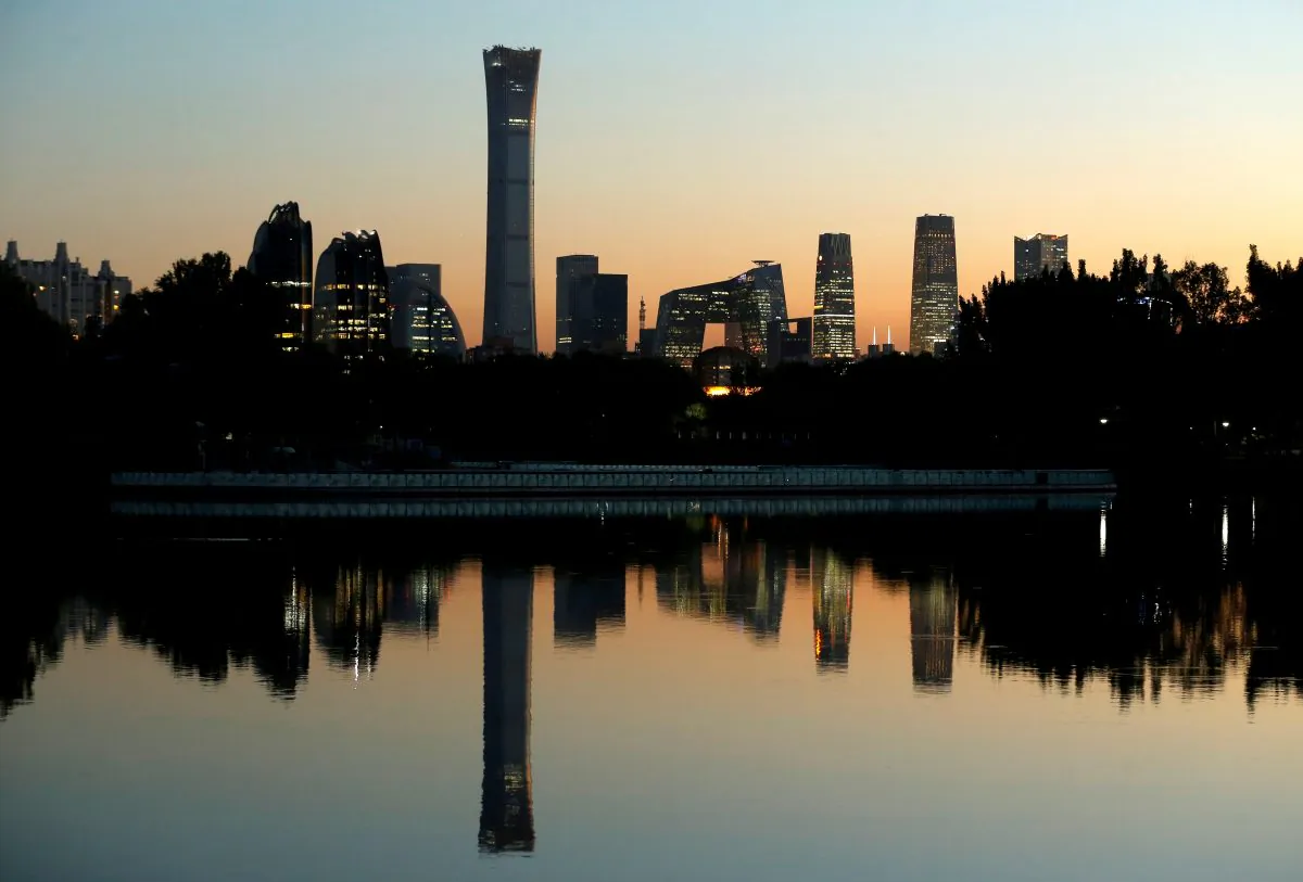 The cityscape of the Beijing Central Business District, or Beijing CBD, is reflected in a pond during sunset on Oct. 17, 2018. (Thomas Peter/Reuters)